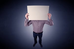 Young businessman hiding behind a blank piece of paper